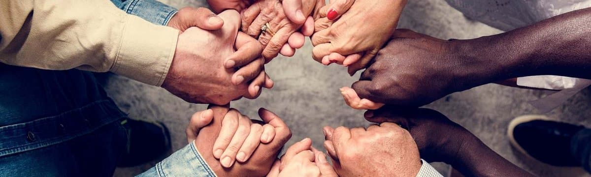Diverse hands joined together, representing a coordinated care team for psychiatric medication management