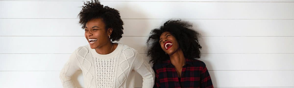 Two friends laughing together outdoors, reflecting healthy connection and confidence built in teen counseling
